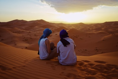 两个男人坐在沙丘
